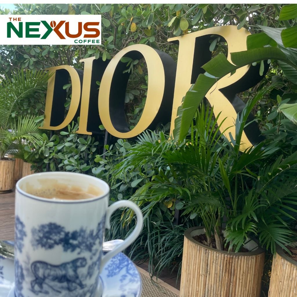 El emblemático letrero dorado del Café Dior rodeado de vegetación en su terraza del Design District.