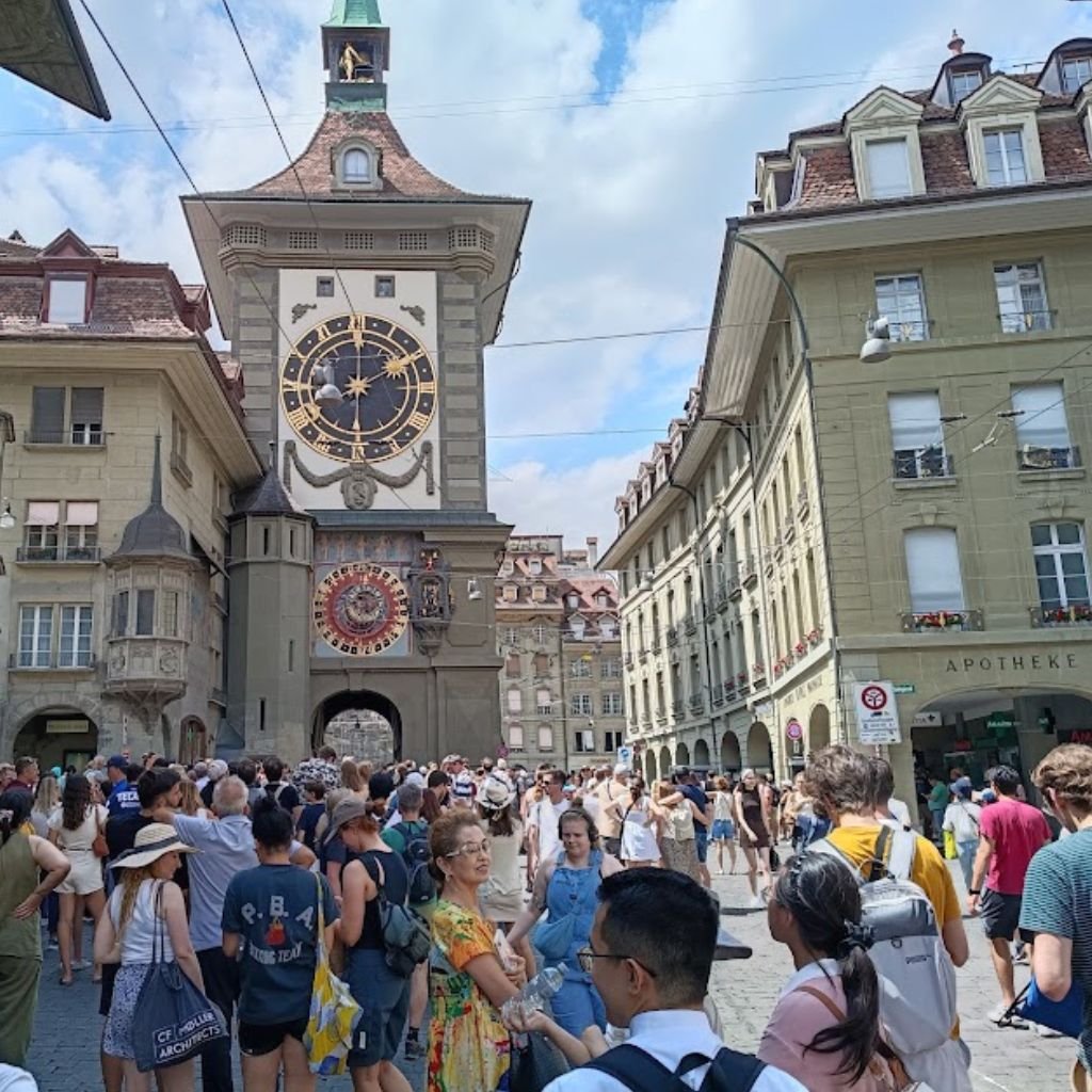 El Zytglogge (Torre del Reloj) de Berna, Suiza: el histórico reloj astronómico del siglo XIII atrae a cientos de turistas que esperan ver su famoso mecanismo en funcionamiento bajo un cielo parcialmente nublado.