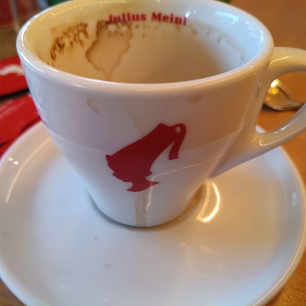 Taza de espresso Julius Meinl con restos de café, símbolo del legado vienés que impulsa la agricultura regenerativa en países de origen.