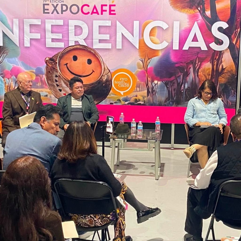 Panel de conferencias de la 29} edición de Expo Café México 2026, con ponentes, público y el lema #YoTomoCafé.