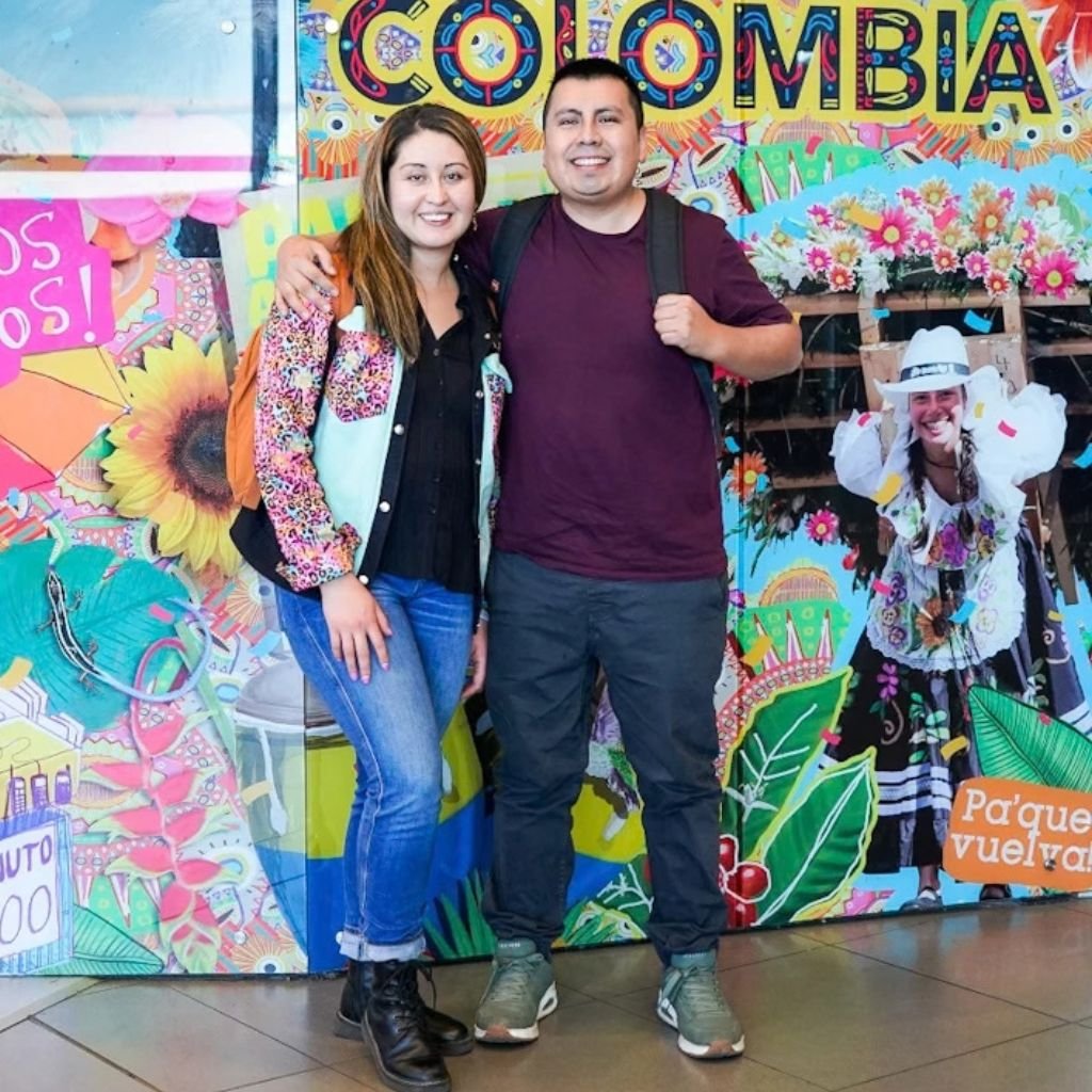 La pareja de emprendedores en Colombia y posa ante un mural colorido que resume su búsqueda constante del café especial en origen.