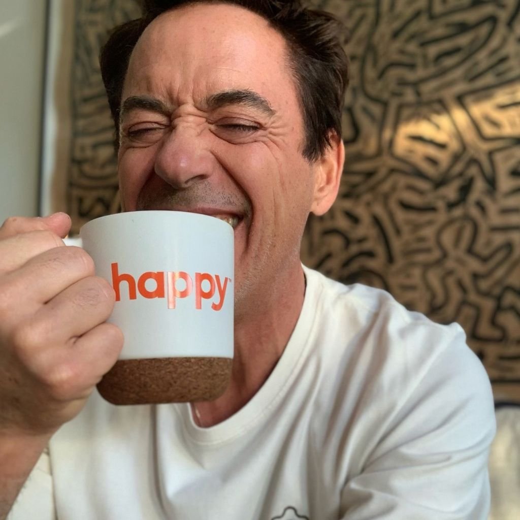 Robert Downey Jr., cofundador de happy®, bebe café en taza de la marca.